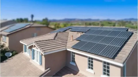 Rooftop solar panels installed on suburban homes under clear skies